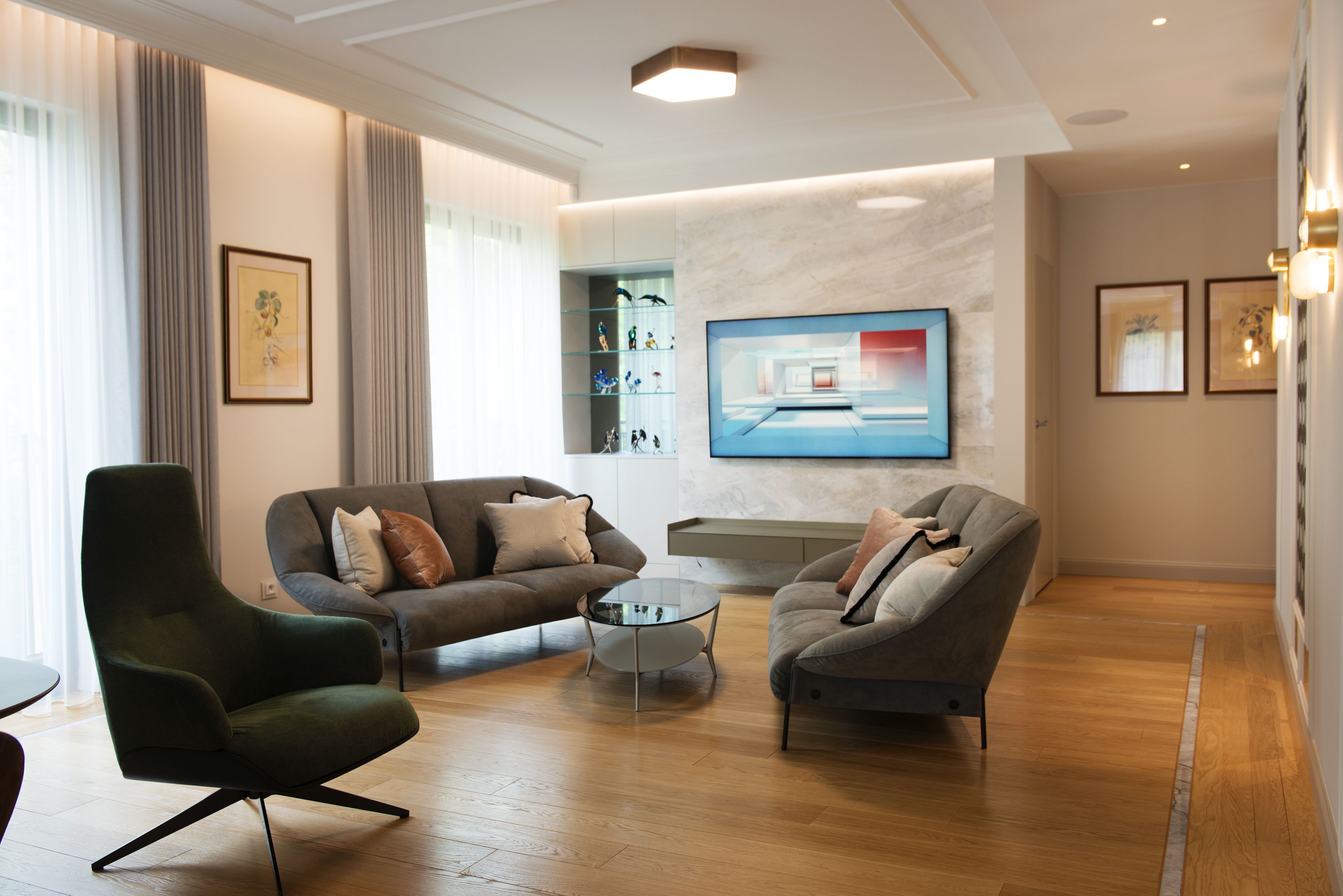 Marmur pojawia się na ścianie z telewizorem oraz w formie lamówki na drewnianej podłodze.